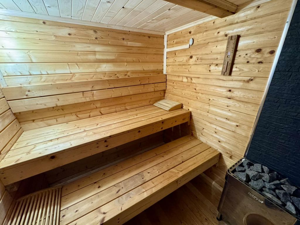 Финландска сауна с дървени пейки и пещ с камъни